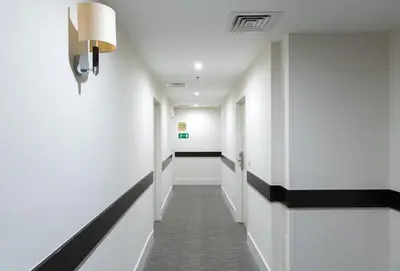 a corridor of a hospital hallway with white walls and black trim at Hotel Chambord in Brussels