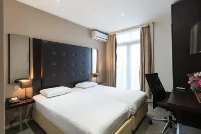 a hotel room with a large bed and a desk at Hotel Chambord in Brussels