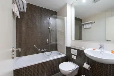 a bathroom with a toilet and a sink and a shower at Hotel Chambord in Brussels