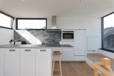 a kitchen with white cabinets and a counter top at Hof Van Spanje in Ghent