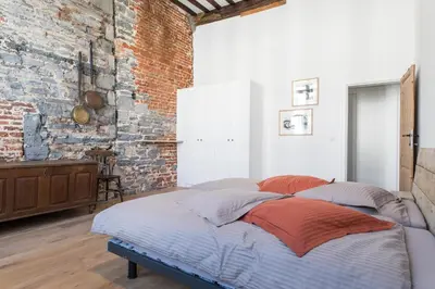 a bed in a room with a brick wall at Hof Van Spanje in Ghent