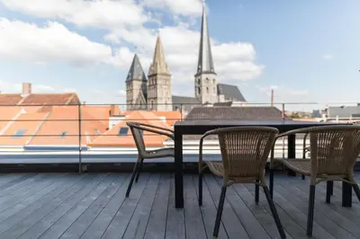 a table and chairs on a balcony with a view of a city at Hof Van Spanje in Ghent