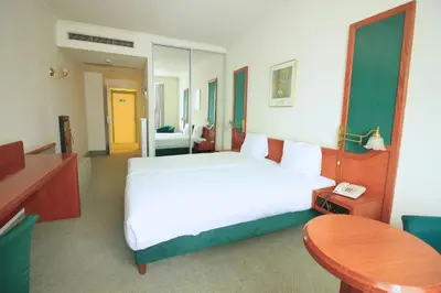 a bedroom with a bed and a table and a telephone at Hotel Le Dome in Brussels