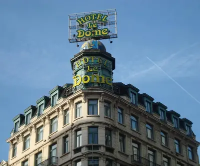 a building with a sign on the top of it at Hotel Le Dome in Brussels