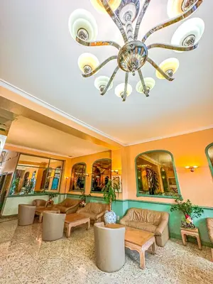 a large living room with a chandelier and furniture at Hotel Le Dome in Brussels
