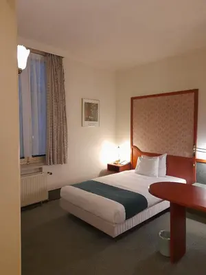 a hotel room with a bed and a table at Hotel Le Dome in Brussels