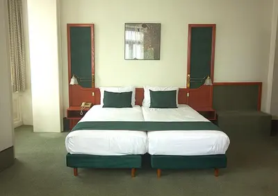 a bedroom with a large bed with two pillows at Hotel Le Dome in Brussels