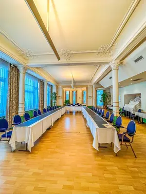 a large banquet hall with long tables and chairs at Hotel Le Dome in Brussels