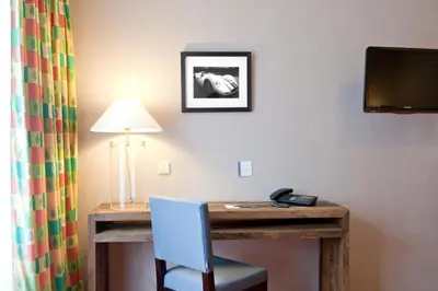 a room with a desk with a lamp and a telephone at New Hotel Charlemagne in Brussels