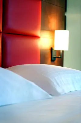 a bed with a white pillow and a lamp at New Hotel Charlemagne in Brussels