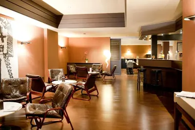 a restaurant with tables and chairs and a bar at New Hotel Charlemagne in Brussels