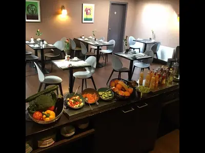 a restaurant with tables and chairs with food on them at New Hotel Charlemagne in Brussels