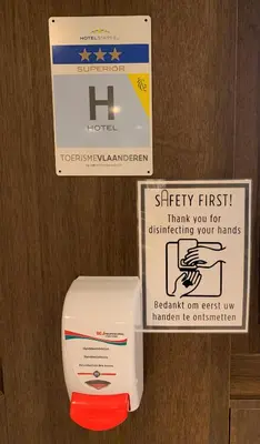 a sign next to a box on a wooden door at Castelnou Aparthotel in Ghent