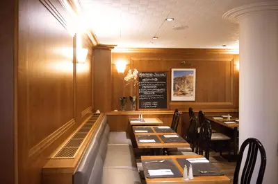 a dining room with tables and a chalkboard on the wall at Castelnou Aparthotel in Ghent