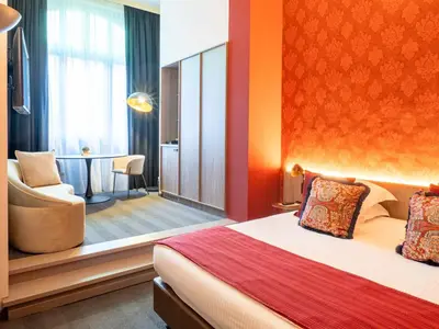 a hotel room with a bed and a chair and a table at Hotel Gravensteen in Ghent
