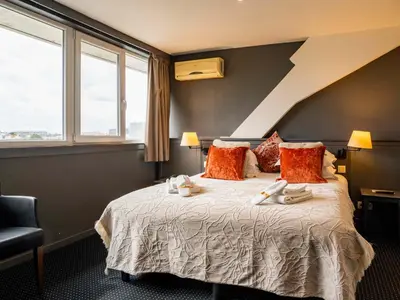 a bedroom with a bed with towels on it at Hotel Gravensteen in Ghent