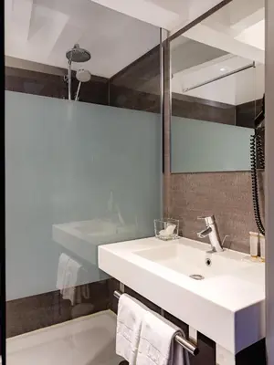 a bathroom with a white sink and a mirror at Hotel Gravensteen in Ghent