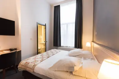 a hotel room with a bed and a window at Hotel Gravensteen in Ghent