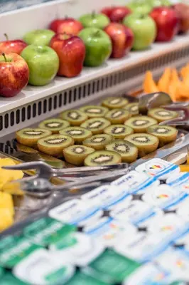 a display case with donuts and apples on display at Hotel Le Plaza Brussels in Brussels