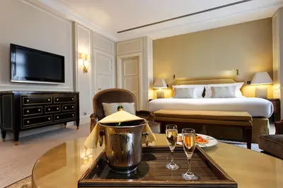 a hotel room with a bed and two glasses of champagne at Hotel Le Plaza Brussels in Brussels