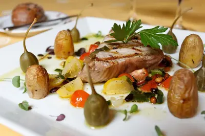 a plate of food with meat and vegetables on a table at Hotel Le Plaza Brussels in Brussels