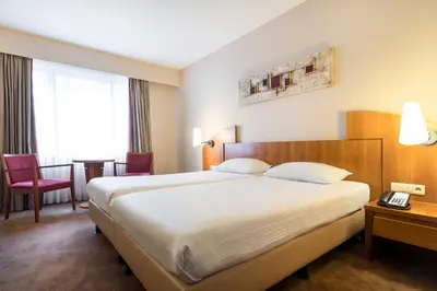 a hotel room with a large bed and a telephone at Astoria Hotel Antwerp in Antwerp
