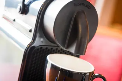 a coffee cup is being brewed in a toaster at Astoria Hotel Antwerp in Antwerp