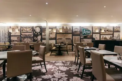 a dining room with tables and chairs in a restaurant at Astoria Hotel Antwerp in Antwerp