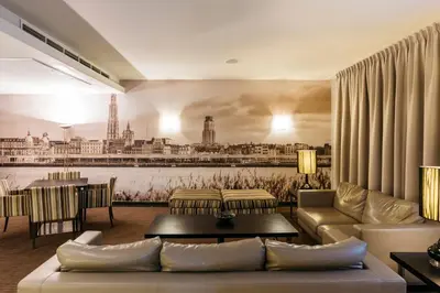 a living room with a mural of a city on the wall at Astoria Hotel Antwerp in Antwerp