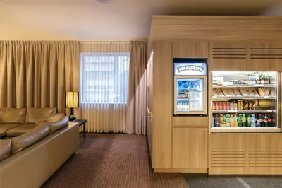 a hotel room with a refrigerator and a couch at Astoria Hotel Antwerp in Antwerp