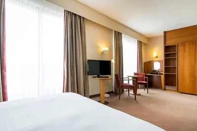 a hotel room with a bed and a desk and a television at Astoria Hotel Antwerp in Antwerp