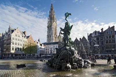 a fountain in the middle of a city with a clock tower at Astoria Hotel Antwerp in Antwerp