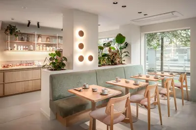 a restaurant with four tables and a green couch at Hotel Chamade in Ghent