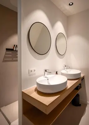 a bathroom with two sinks and two mirrors at Hotel Chamade in Ghent