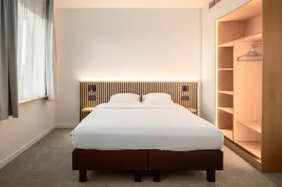 a bedroom with a large bed with white sheets at Hotel Chamade in Ghent