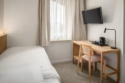 a hotel room with a desk and a bed and a bed and a desk at Hotel Chamade in Ghent
