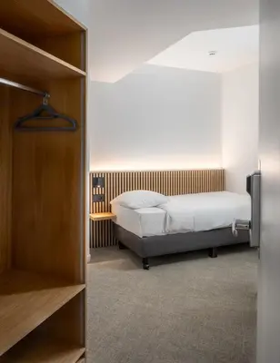 a bedroom with a bed and a closet at Hotel Chamade in Ghent