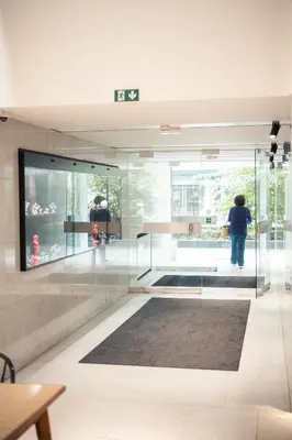 a person standing in a room with glass walls at Hotel Queen Anne in Brussels