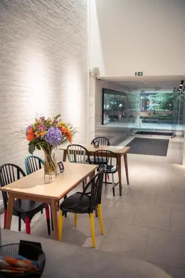 a dining room with tables and chairs with flowers on them at Hotel Queen Anne in Brussels
