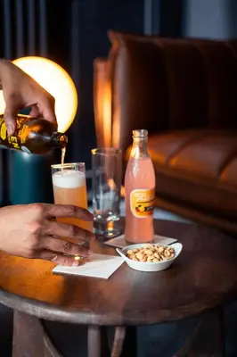 a person is pouring a drink on a table at Hotel Queen Anne in Brussels