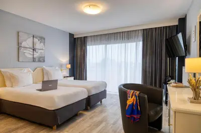 a hotel room with a bed and a laptop on a chair at First Euroflat Hotel in Brussels