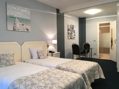 a hotel room with two beds and a table at First Euroflat Hotel in Brussels