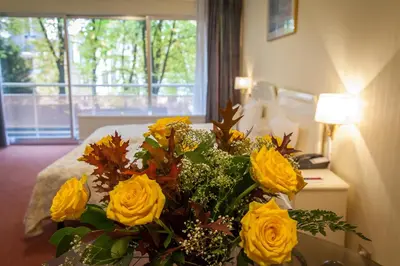 a bouquet of yellow roses in a hotel room at First Euroflat Hotel in Brussels