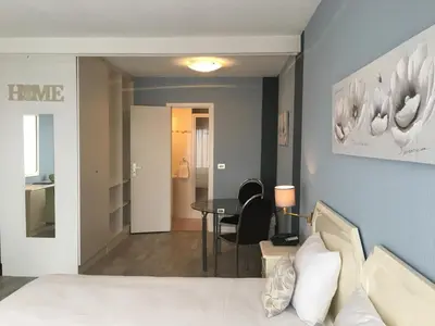 a bedroom with a bed and a dining room table at First Euroflat Hotel in Brussels