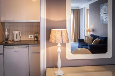 a lamp in a kitchen with a living room at First Euroflat Hotel in Brussels