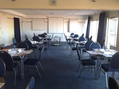 a classroom with tables and chairs in a room at First Euroflat Hotel in Brussels