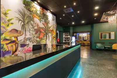 a lobby of a restaurant with a tropical mural on the wall at Thon Hotel Bristol Stephanie in Brussels