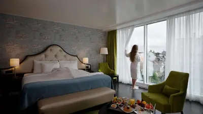a woman standing in a hotel room looking out the window at Thon Hotel Bristol Stephanie in Brussels