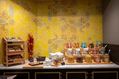 a display of food on a table with a yellow wall at Thon Hotel Bristol Stephanie in Brussels