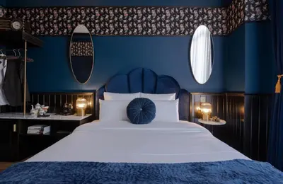 a blue bedroom with a large bed with a blue headboard at Craves in Brussels